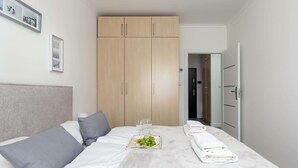 Une chambre d’hôtel avec un lit, une armoire et une assiette de fruits.