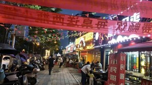 A street lined with restaurants and shops, decorated with colorful banners and lights. - Vienna Hotel (Jingzhou Jianli Jiangcheng) (Jianli)