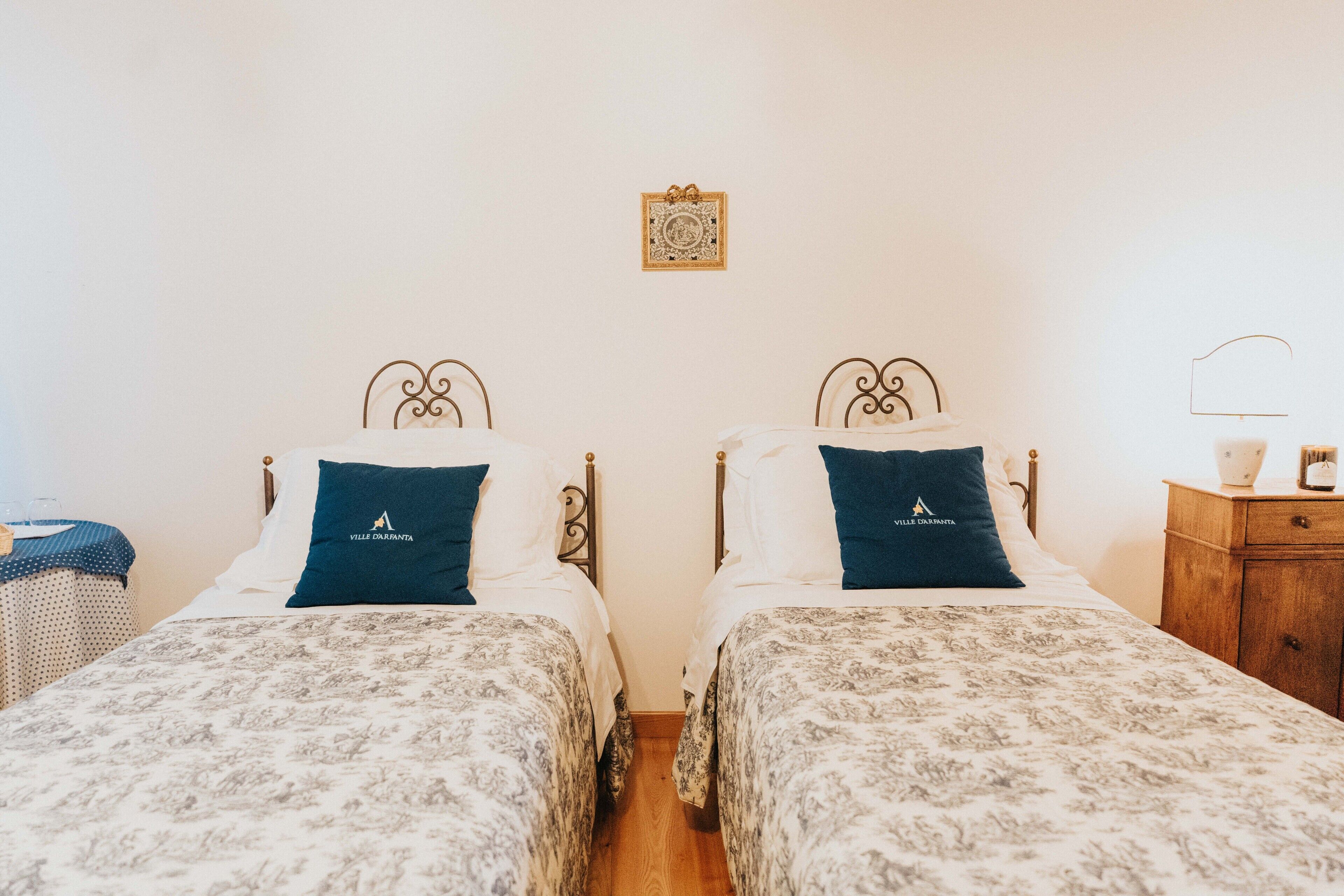 Habitación doble con dos camas, cada una con almohada y cabecera a juego.