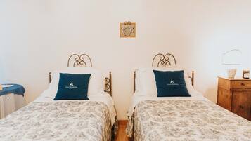 Habitación doble con dos camas, cada una con almohada y cabecera a juego.