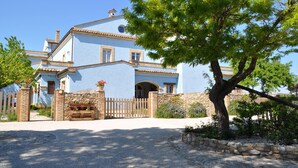 A two-story building with a light blue facade, a stone wall, and a wooden gate. - LA MASSERIA - La Colombaia - 6 (Vasto)