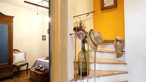Eine Treppe mit Metallgeländer, eine Vase mit Blumen und ein Hut auf dem Geländer.