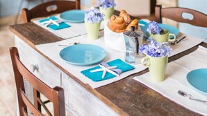 A dining table set with plates, napkins, and a vase of flowers. - LA MASSERIA - La Rimessa - 9 (Vasto)