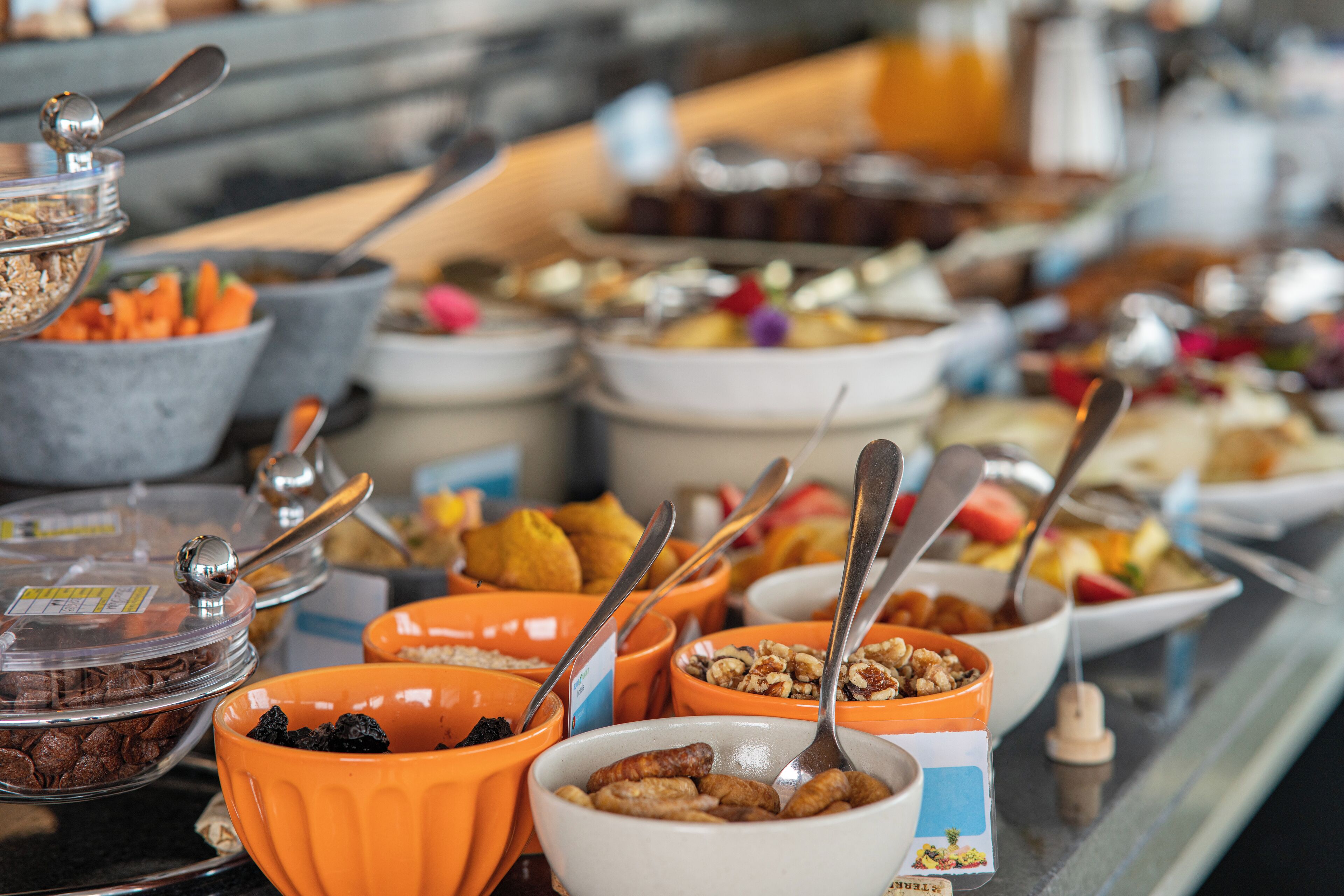 A buffet with various food items and utensils.