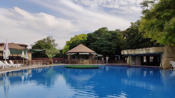 A swimming pool with lounge chairs and a gazebo. - Al Baiara Resort (Jericho)