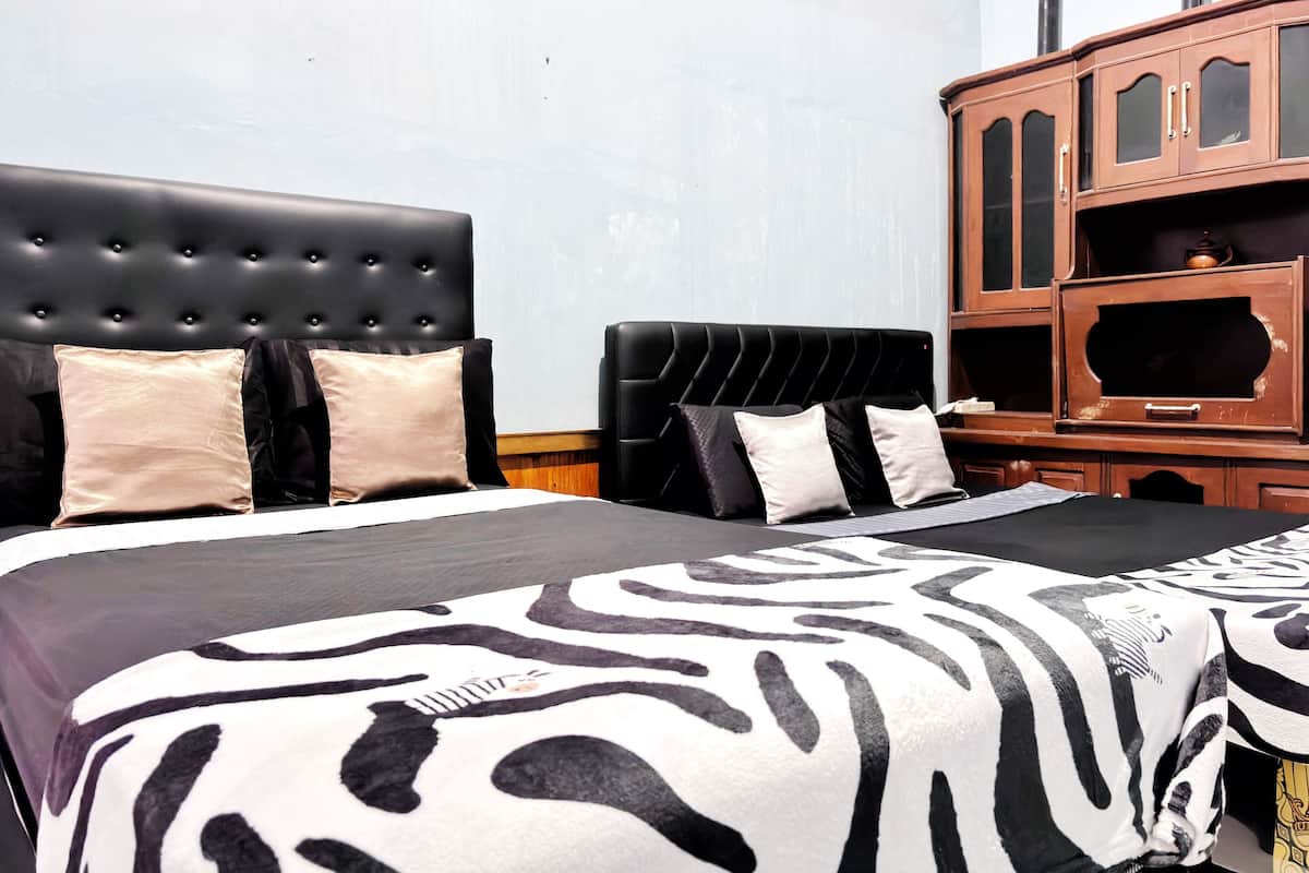 A hotel room with a large bed, a wooden cabinet, and a television.
