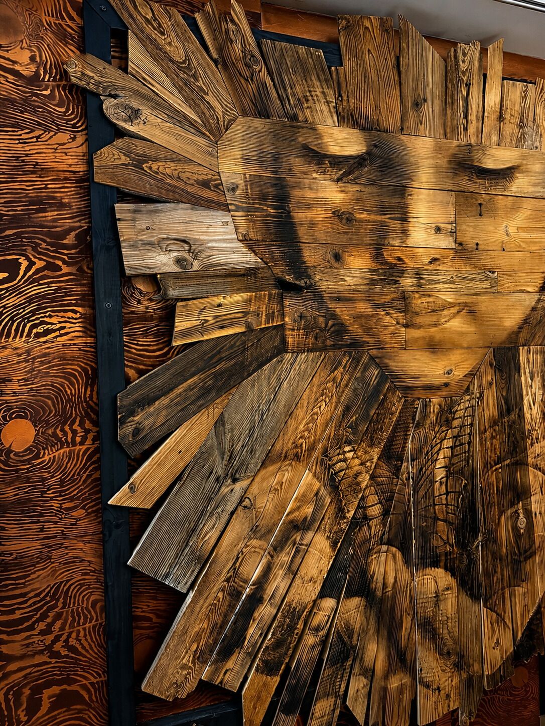 A wall with a variety of wooden planks arranged in a radial pattern.