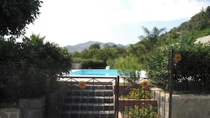 A gated pool area with a view of mountains in the background. - Agriturismo Ghiritina (Francavilla di Sicilia)