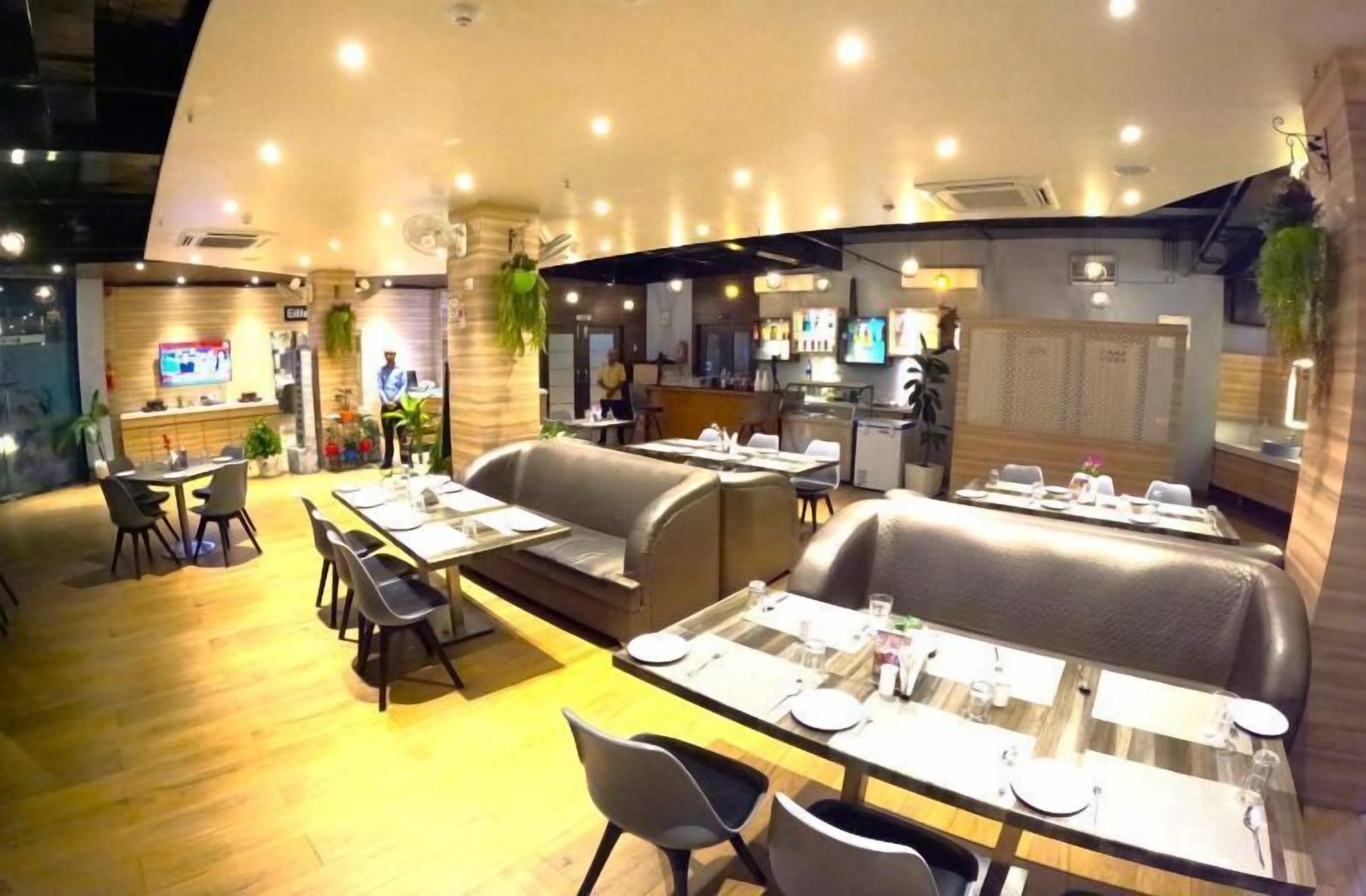 A restaurant with booths and tables, a counter, and a TV screen.