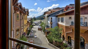 A street view of a town with buildings, a café, and a mountain in the background.