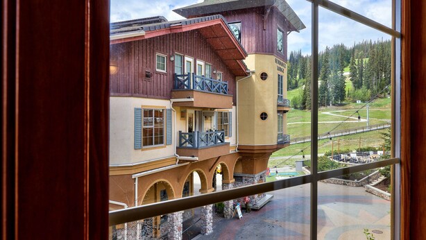 A multi-story building with a balcony, arched windows, and a clock tower.