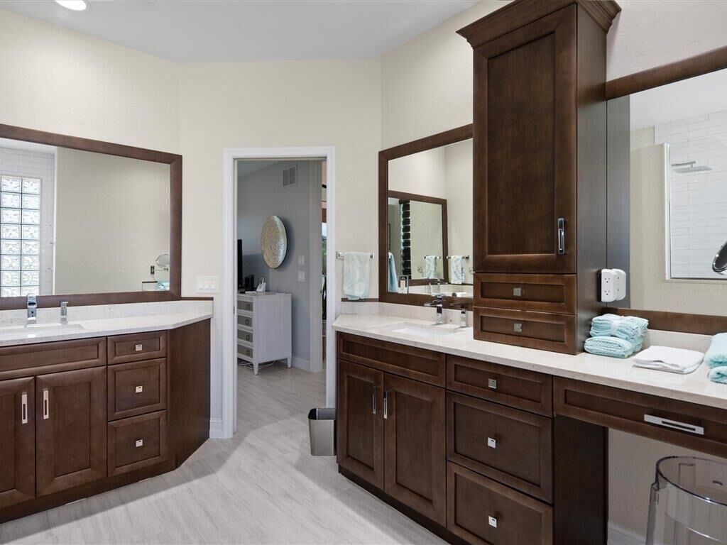 A bathroom with two sinks, dark wooden cabinets, and a large mirror.