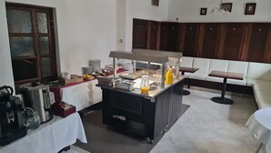 Montaje de bufé con diversas opciones de comida y una máquina de café.