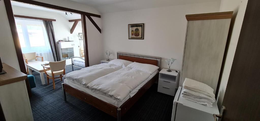 Una habitación de hotel con cama, mesitas de noche, un escritorio y una silla.