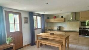Una cocina moderna con armarios de madera, horno empotrado y cafetera.