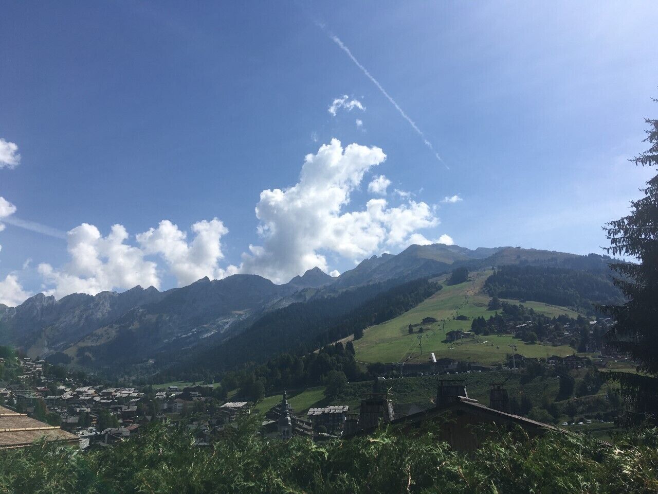 Eine gebirgige Landschaft, in deren Tal ein Dorf liegt.