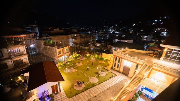 Vista aérea de un patio central con un área de estar, rodeado de edificios con balcones y ventanas.