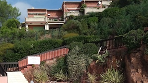 Une piscine à l’eau d’un bleu limpide, entourée d’un mur de pierre et de verdure.