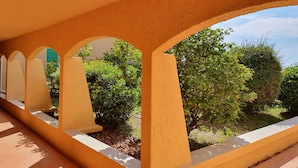 Un couloir orné d’arches, d’où l’on peut admirer la verdure environnante.