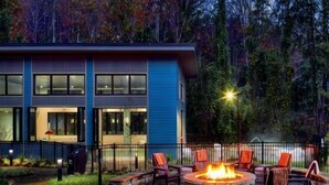 A modern building with a fire pit and outdoor seating.