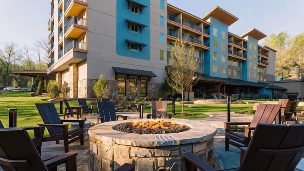A hotel with outdoor seating, a fire pit, and a well-maintained lawn.