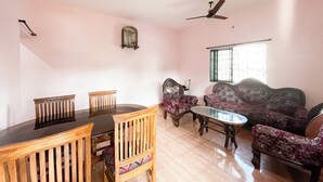 A living room with a dining table, two chairs, a sofa set, and ceiling fans. - SPACELAND Mandrem (Mandrem)