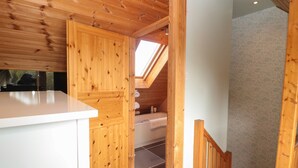 A compact kitchen with wooden walls and a small window. - Swallow Lodge (Morpeth)