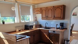 Una cocina con armarios de madera, una isla integrada, un fregadero y una cafetera.