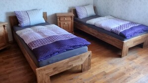 Una habitación con dos camas de madera, techo de madera y pared con diseño.