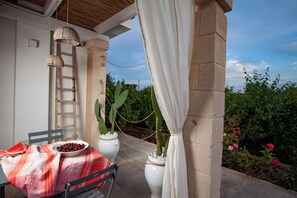 An outdoor patio with a table set for dining, a ladder, and potted plants. - Casa Mia in Puglia (Conversano)