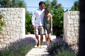 A couple walking on a stone pathway surrounded by lavender plants. - Casa Mia in Puglia (Conversano)