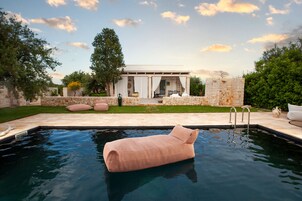 Una piscina al aire libre, sombrillas, tumbonas