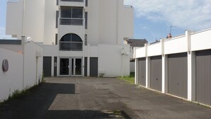 Un bâtiment moderne doté d’une entrée centrale, de plusieurs étages et d’un espace de stationnement à l’avant.