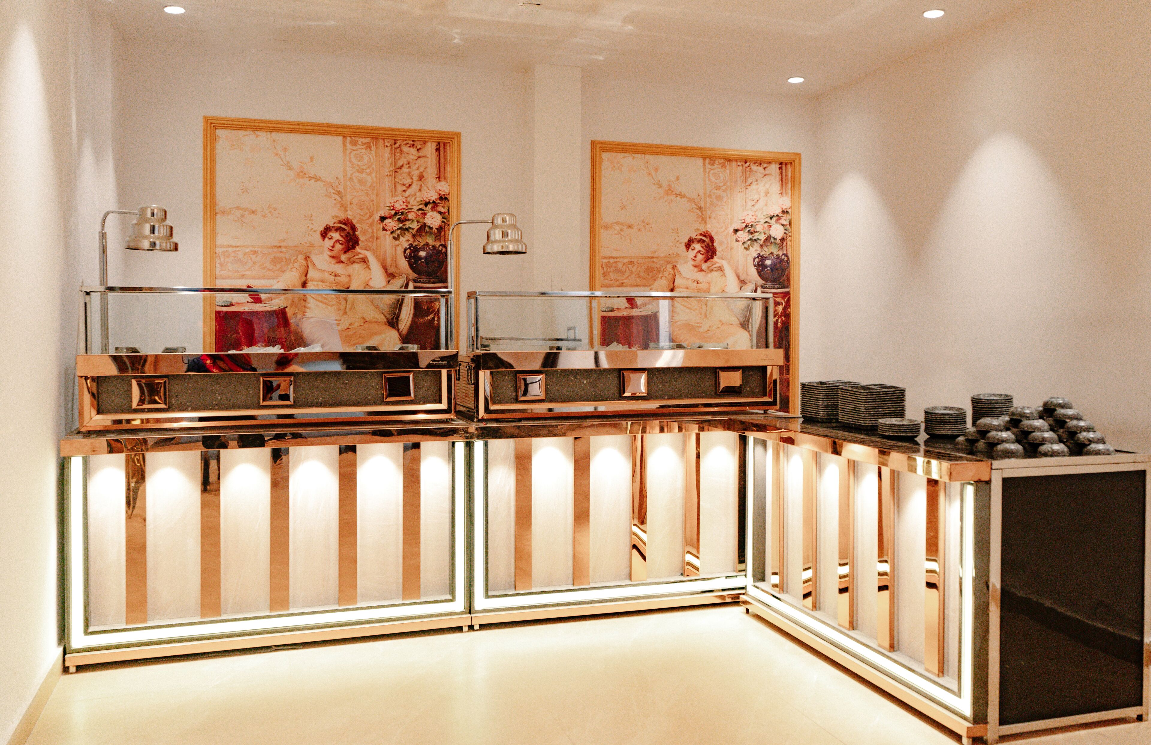 Un área de recepción de diseño moderno, con un separador de vidrio, mostrador de madera y una lámpara de pared.