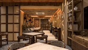 Un restaurante con muebles de madera, una pared con diseño y un techo con motivos geométricos.