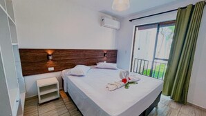 A hotel room with a bed, a nightstand, a wall-mounted air conditioner, and a view of the outdoors. - Pousada Mar a Vista (Ipojuca)