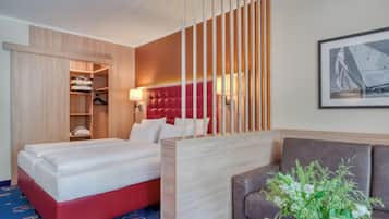 Ein Hotelzimmer mit einem Bett, einer Sitzecke, einem Kleiderschrank und einer Wandlampe.