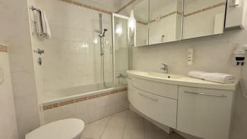 Ein Badezimmer mit Toilette, Dusche, Waschbecken und Spiegel.