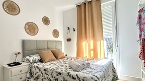 A bedroom with a bed, nightstand, and a view of the outside. - Casa Secunda Romar (Córdoba)