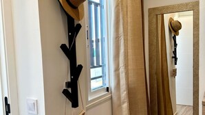 A hallway with a mirror, a hat, and a coat rack. - Casa Secunda Romar (Córdoba)