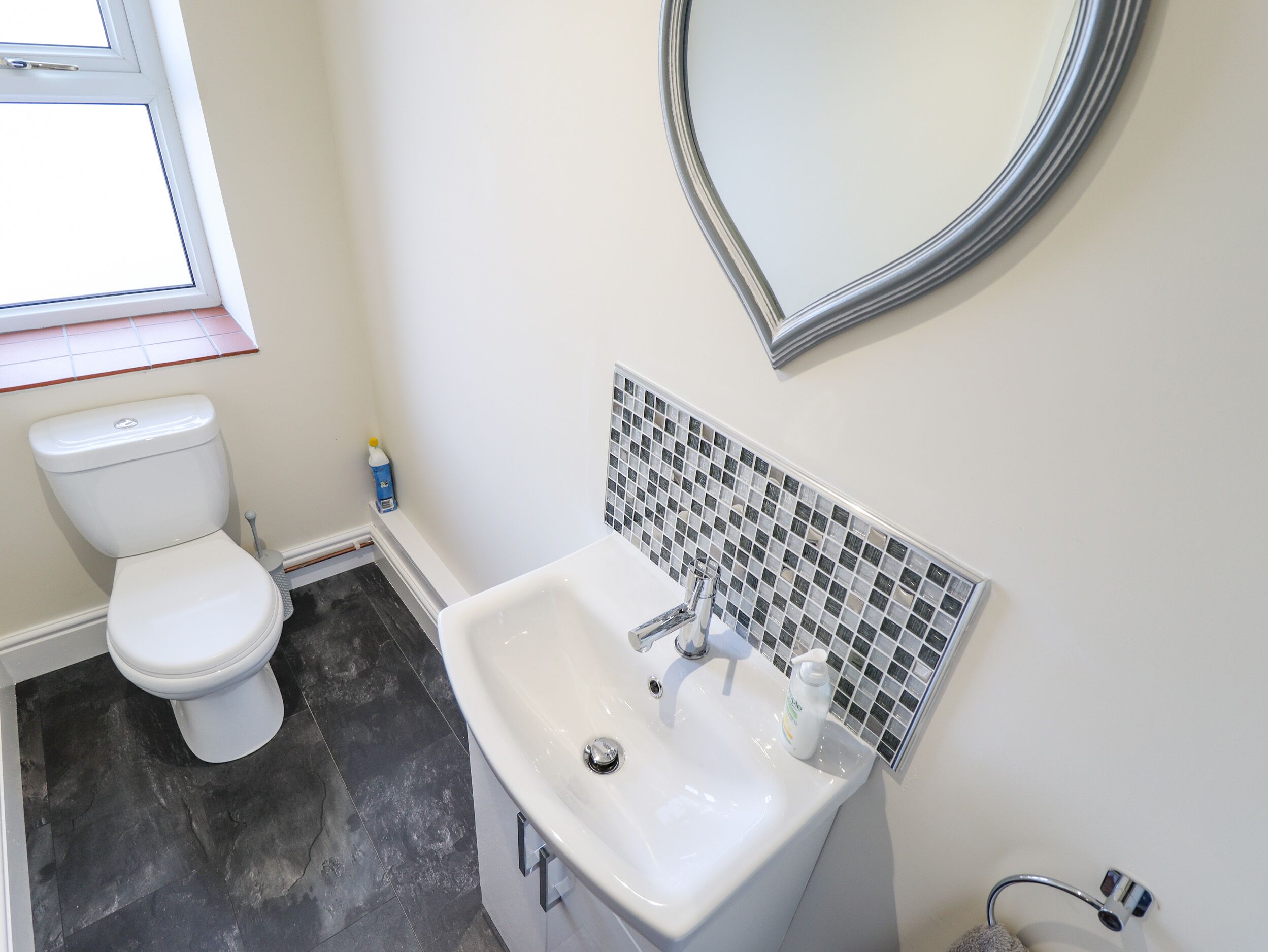 Un baño con inodoro, lavabo y espejo.