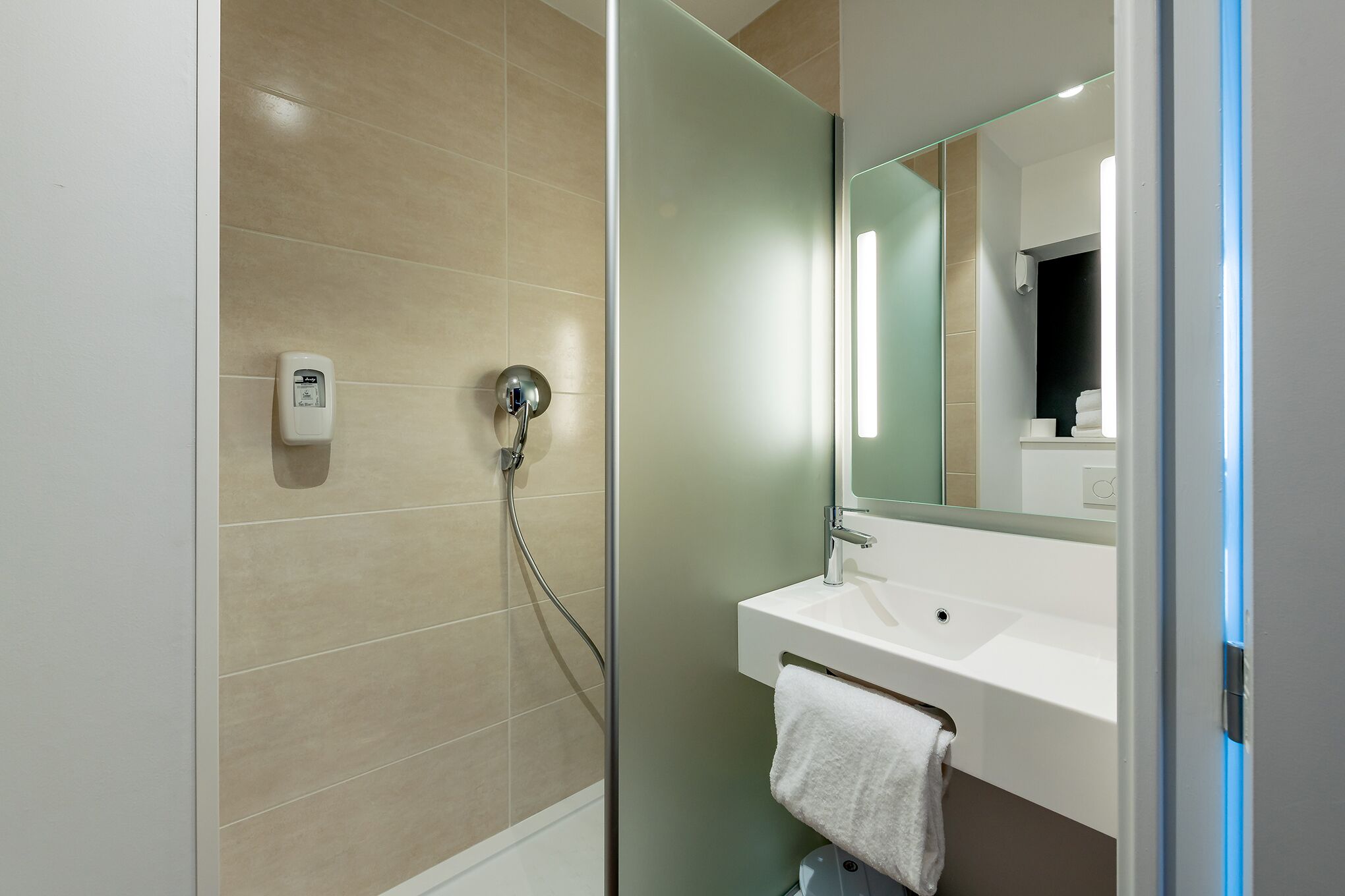 Een douche, handdoeken, zeep, shampoo
