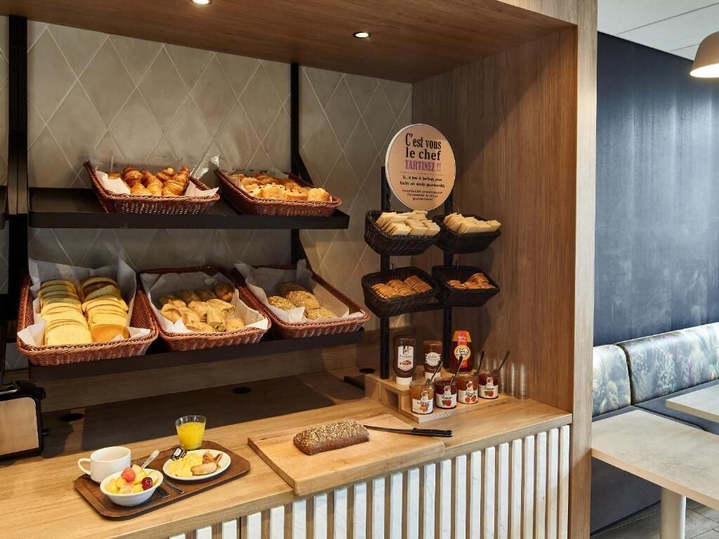 Un bufé de desayuno con panes, pasteles y salsas diversas.