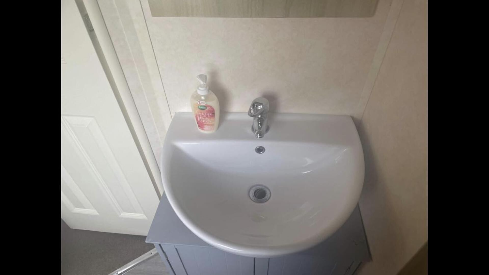 Un lavabo de salle de bain avec un distributeur de savon et un robinet.
