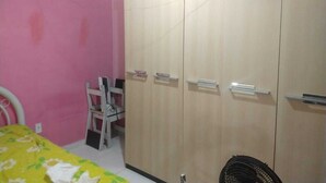 Ein Schlafzimmer mit Bett, Schreibtisch, Stuhl und Kleiderschrank.