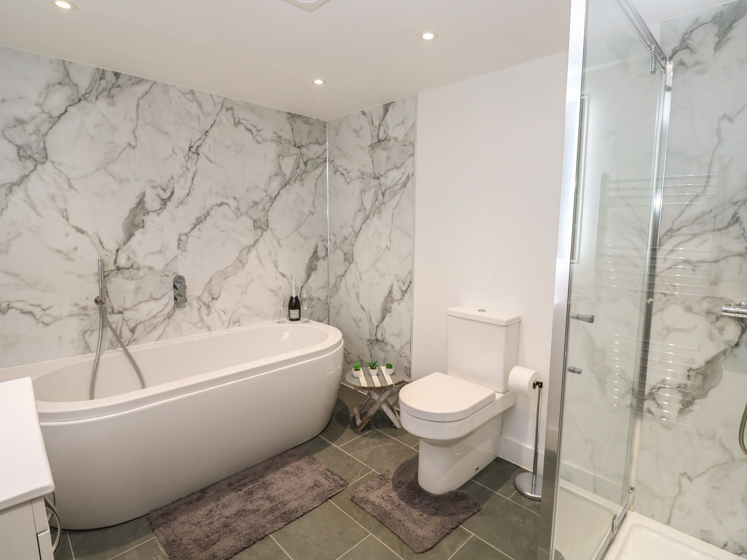 A bathroom with a freestanding bathtub, a toilet, and a glass-enclosed shower.
