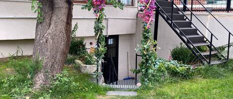 Un camino que lleva a un edificio con escaleras y un árbol.