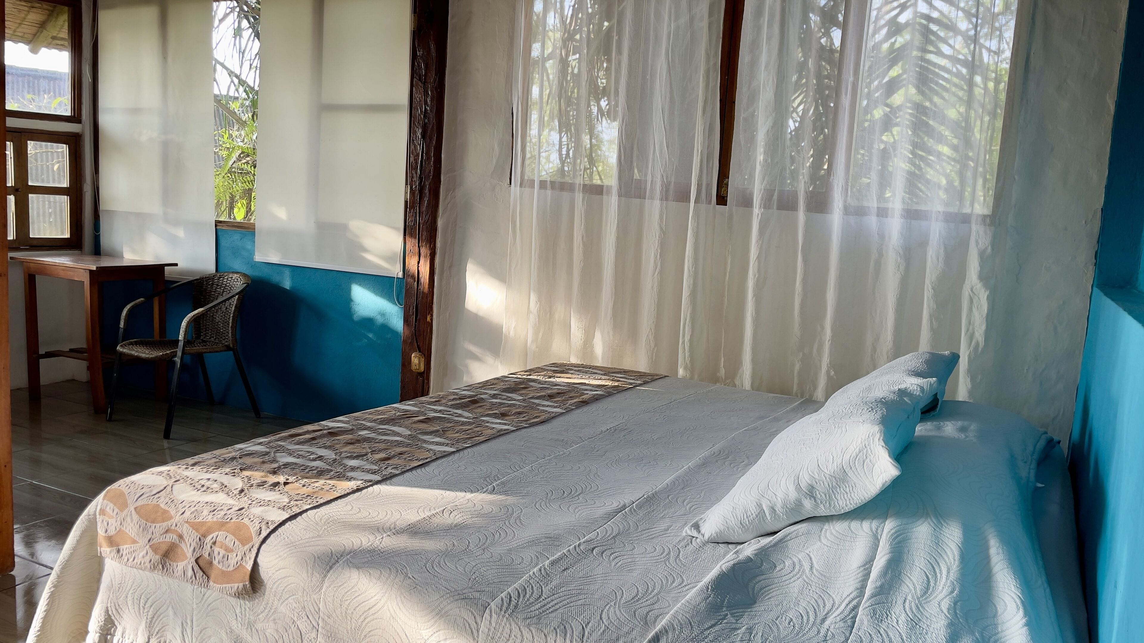 A room with a bed, a desk, and a chair.