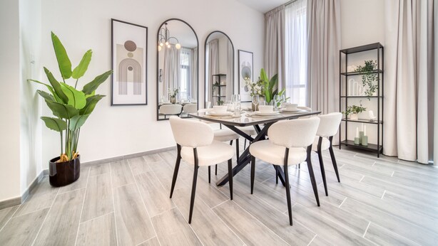 Un comedor moderno con una mesa redonda, seis sillas y una planta en maceta.