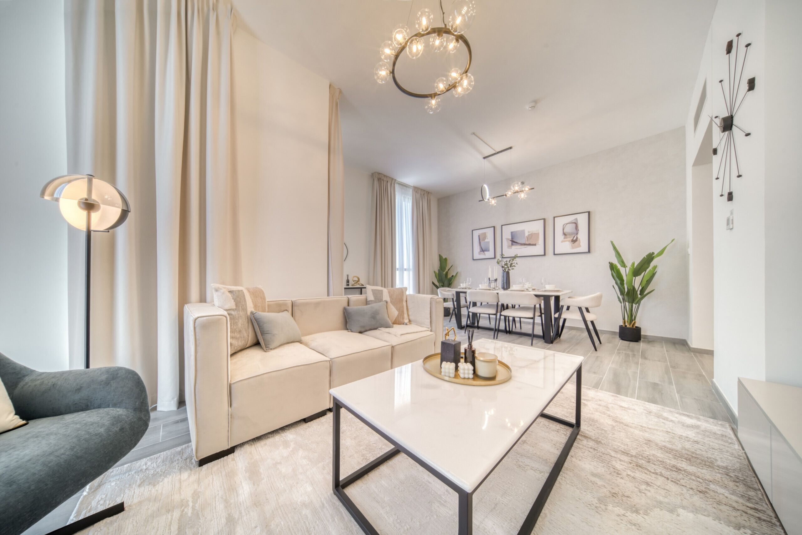 A modern living room with a sofa, coffee table, and dining area.